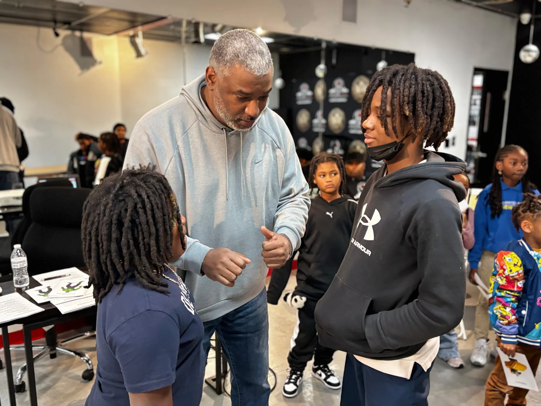 A mentor guiding young people during a Reed's Refuge workshop