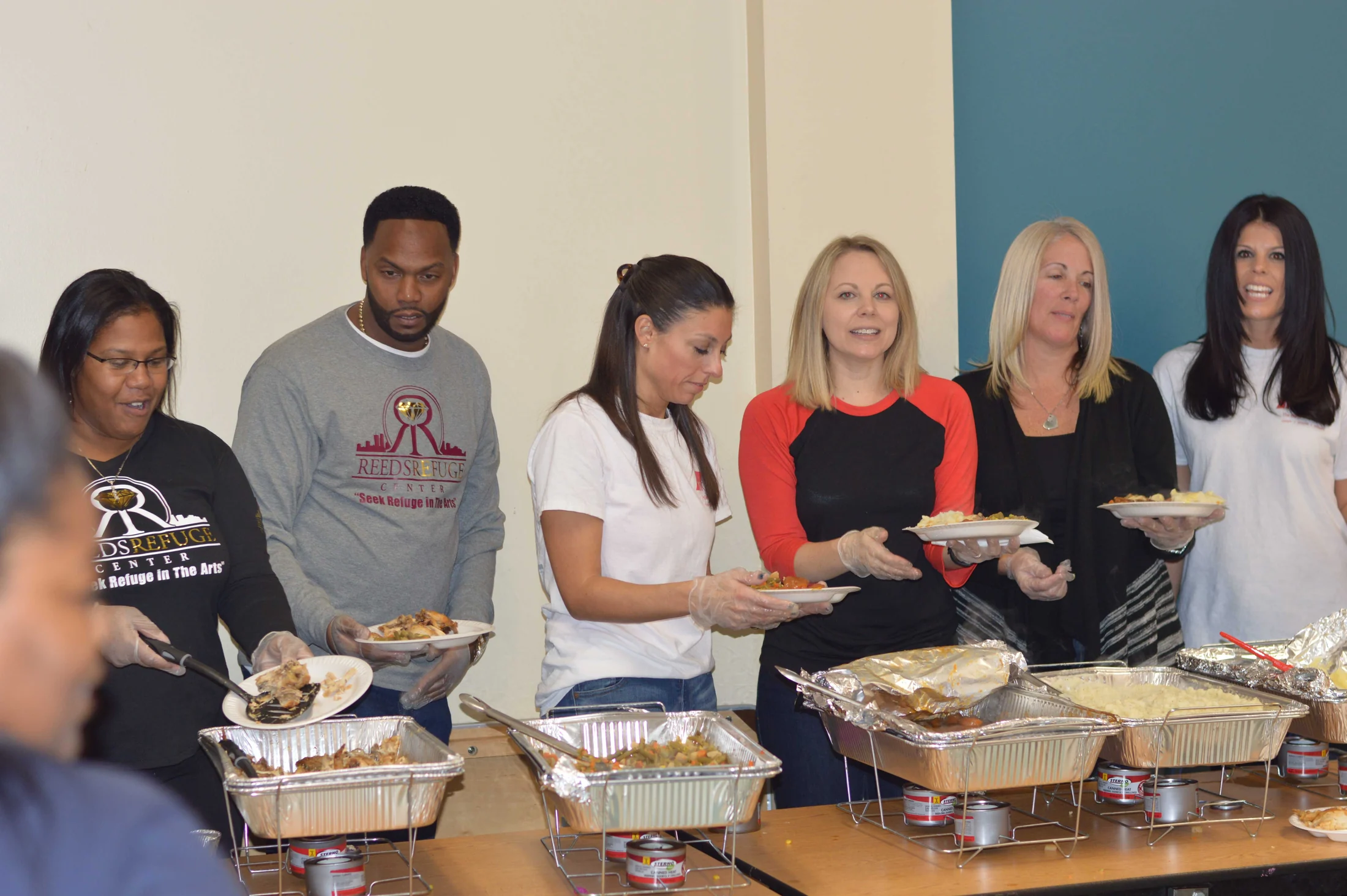 Reed’s Refuge staff and volunteers sharing a community meal