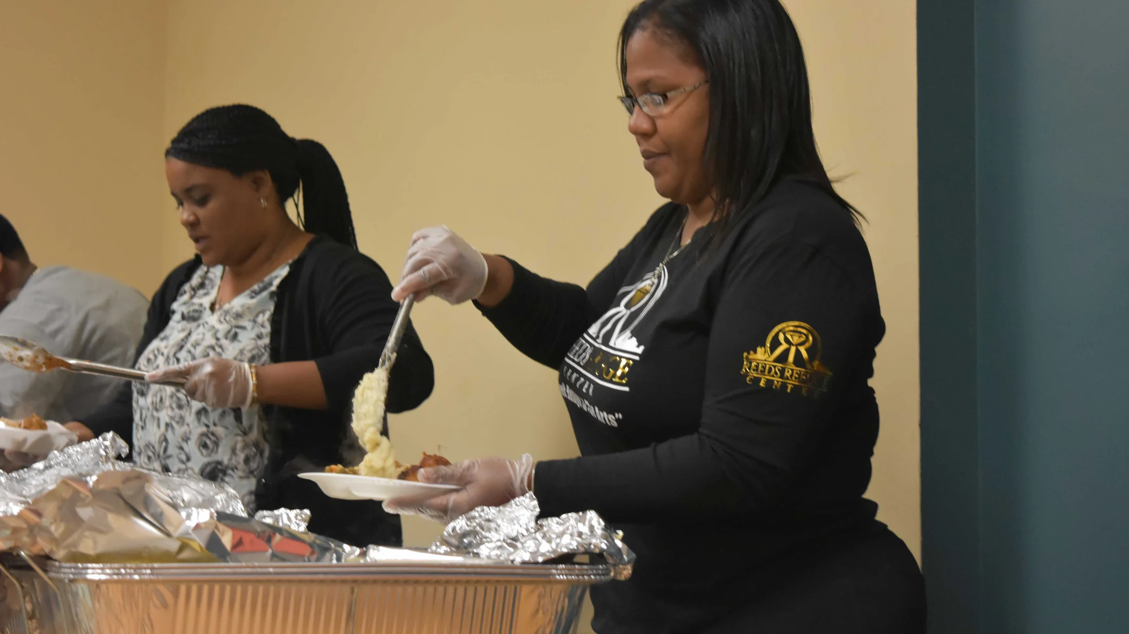 Volunteers serving a community meal at Reed’s Refuge Center